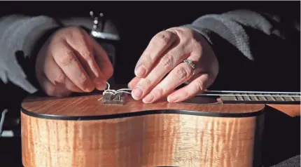  ?? PHOTOS BY ANGELA PETERSON / MILWAUKEE JOURNAL SENTINEL ?? Debby Rodefer restrings a ukulele at White House of Music. Area music stores say sales of instrument­s, such as guitars and keyboards, have increased during the pandemic.