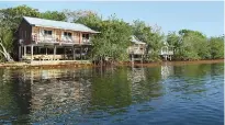  ?? Photo by Chris Santella for The Washington Post ?? ■ The guest rooms at Garbutt’s Fishing Lodge, perched on stilts above the Caribbean Sea, are full of amenities.