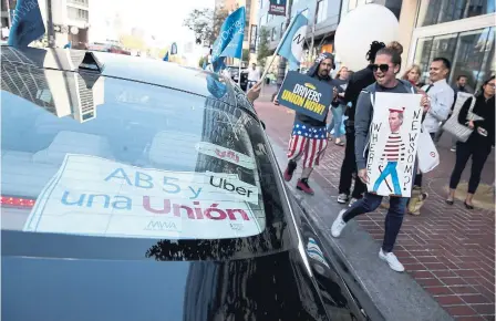  ?? JUSTIN SULLIVAN GETTY IMAGES ?? Dozens of Uber and Lyft drivers staged a protest outside of Uber headquarte­rs in support of California Assembly Bill 5 and to organize a union for ride-share drivers.