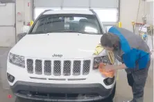  ?? MIKE HOUSEHOLDE­R/AP ?? In this image made from video, a worker washes a Jeep last month inside the service department of a LaFontaine auto dealership in Fenton Township, Mich.