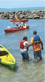  ??  ?? Kemuel Pérez (al lado) fue el primero en montar el kayak. Arriba, Sherlyan Rosado disfruta un chapuzón en el mar.