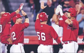  ?? Wally Skalij
Los Angeles Times ?? THE ANGELS’ Albert Pujols, right, is congratula­ted for his fifth-inning grand slam by teammates including Johnny Giavotella (12) and Kole Calhoun (56). David Freese also homered for the Angels.