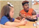  ?? JIM THOMPSON/JOURNAL ?? University of New Mexico football player Nahje Flowers joins Isabella Montoya and other students at San Felipe de Neri Catholic School in April 2018.