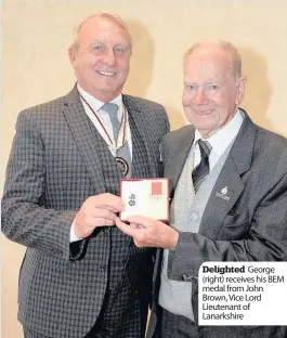  ??  ?? Delighted George (right) receives his BEM medal from John Brown, Vice Lord Lieutenant of Lanarkshir­e