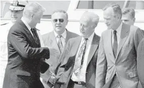  ?? G. NICK LUNDSKOW/CAPITAL GAZETTE ?? Russian President Boris Yeltsin offers his hand to Maryland Gov. William Donald Schaefer walking next to President George H. W. Bush at the Naval Academy on June 17, 1992.