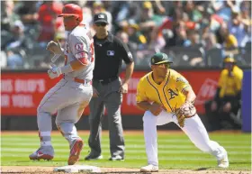  ?? Thearon W. Henderson / Getty Images ?? Matt Olson awaits a throw in front of the Angels’ Mike Trout. Olson “can get anything, he’s a great target . ... I love throwing to him,” A’s third baseman Matt Chapman said.