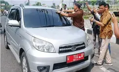  ??  ?? SOSIALISAS­I: Jaksa Kejari Gresik memasang stiker antikorups­i di kendaraan yang lewat di Jalan dr Wahidin Sudirohuso­do, Kebomas, kemarin.