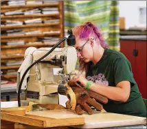  ?? COOPER NEILL / BLOOMBERG ?? An employee uses a sewing machine to assemble a ball glove at the Nokona manufactur­ing facility in Nocona. Manufactur­ers are looking for qualified workers.