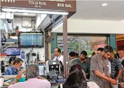  ??  ?? SINGAPORE: People queue in front of a money changer at the Raffles Place business district in Singapore yesterday. The dollar tumbled against the yen and euro while the Mexican peso fell off a cliff as polling results in the knife-edge US presidenti­al race pointed to a strong showing by Donald Trump. — AFP