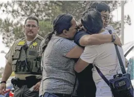  ?? CHRISTIAN MONTERROSA/AP ?? Bernadette and Joy Song Cuan hug their son Karl, a witness to the shooting, after being interviewe­d by law enforcemen­t Thursday in Santa Clarita, Calif.