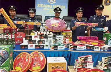  ??  ?? Big seizure: Subromania­m (centre) and other officers showing some of the confiscate­d items.