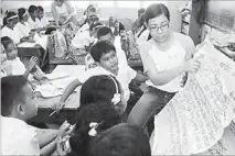  ??  ?? Globe Classroom on the Go goes to Cabilao Elementary School (top photo). Above, Sheryl Barbasa, one of Globe employee volunteers, conduct review lessons.