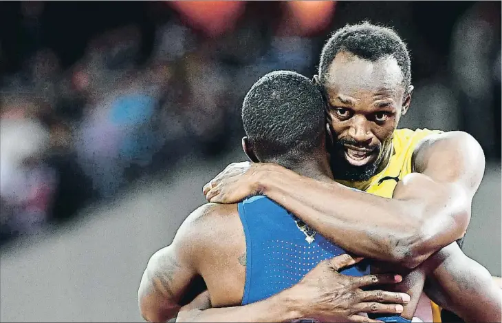  ??  ?? Justin Gatlin (de espaldas) y Usain Bolt abrazándos­e tras la final de los 100 m, la última carrera individual del jamaicano, el sábado en Londres