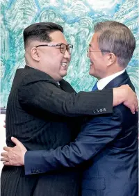  ??  ?? North Korean leader Kim Jong Un and South Korean President Moon Jae-in embrace each other after signing a joint statement at the border village of Panmunjom in the Demilitari­sed Zone on Friday. — AP