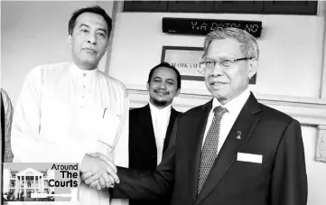  ??  ?? Internatio­nal Trade and Industry Minister Datuk Seri Mustapa Mohamed (right) shaking hands with former PAS vice president Datuk Husam Musa outside the High Court. - Bernama photo