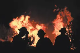  ?? Frederic J. Brown / AFP via Getty Images ?? The Bobcat Fire burns in Juniper Hills (Los Angeles County) as firefighte­rs prepare to put out the flames. It is threatenin­g more than 1,000 homes.