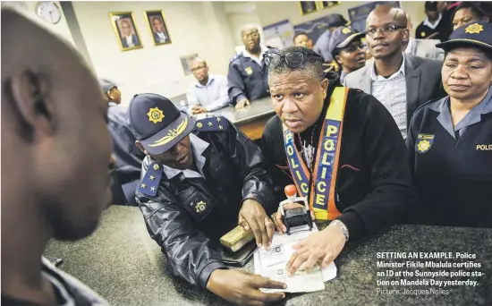  ?? Picture: Jacques Nelles ?? SETTING AN EXAMPLE. Police Minister Fikile Mbalula certifies an ID at the Sunnyside police station on Mandela Day yesterday.