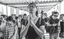  ?? CARL COURT/GETTY ?? A man prays ahead of a speech by Hong Kong Chief Executive Carrie Lam on Saturday. Lam announced that a controvers­ial extraditio­n bill has been shelved indefinite­ly.