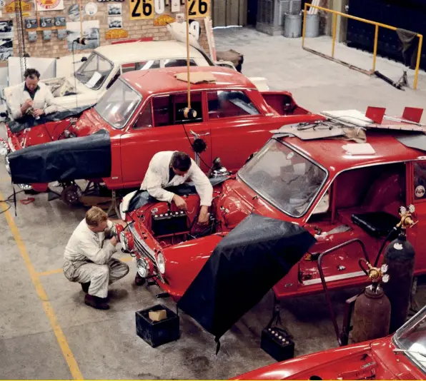  ??  ?? This is a very rare workshop shot from Boreham in the winter of 1963/1964, with a brand-new bright red Cortina GTs being prepared for rallying.