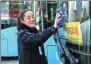  ?? ZHU LIXIN / CHINA DAILY ?? Driver Yang Miaomiao, in Bengbu, Anhui province, a delegate to the 19th CPC National Congress, cleans her bus in November.