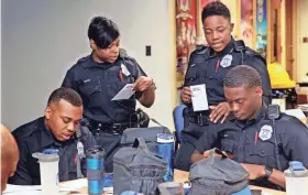  ?? ANGELA PETERSON / MILWAUKEE JOURNAL SENTINEL ?? Milwaukee police recruit Jennifer Beamon (standing right), 30, works with her classmates Michael Jones (from left), 31, Monica Davis, 26, and Jamar Lucky, 25, at the police academy.