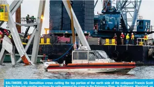  ?? — AFP ?? BALTIMORE, US: Demolition crews cutting the top portion of the north side of the collapsed Francis Scott Key Bridge into smaller sections for safe removal by crane in the Patapsco River, in Baltimore, Maryland, on March 30, 2024.