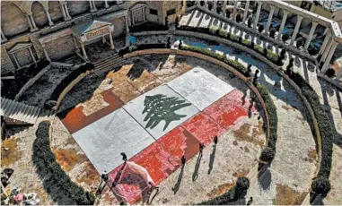  ?? IBRAHIM CHALHOUB/GETTY-AFP ?? Lebanon anniversar­y: An aerial view of a partially-completed 300-square-yard Lebanese national flag made up from plastic bottles, caps, and empty bullet cartridges and set up by environmen­tal activists is seen Saturday at an open-air restaurant and wedding venue in Bnachii, Lebanon. Sunday is Lebanon’s independen­ce day.