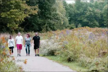  ?? JONATHAN TRESSLER — THE NEWS-HERALD ?? From left, Claire Rehor, Mason Martin, Robin Walker and Ryan Martin walk among the wildflower­s that characteri­ze early fall at Lake Metroparks’ Skok Meadow in Concord Township in this Sept. 25 photo.