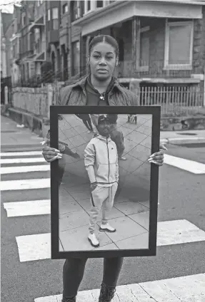  ?? PHOTOS BY MAX HERMAN/USA TODAY ?? Shawntell Nile, 33, holds a photo of her brother Jajuan near the former Ida B. Wells Homes public housing project in Chicago, where he lived.