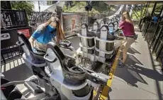  ?? Mel Melcon Los Angeles Times ?? REOPENING JUNE 15 means we’ll have a normal summer, George Skelton writes. Above, sanitizing a ride at Six Flags Magic Mountain.