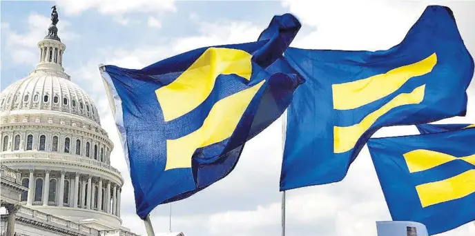  ?? AP fiLE ?? GENDER BENDER: People with the Human Rights Campaign hold up ‘equality flags’ during an event on Capitol Hill in Washington, D.C., in support of transgende­r members of the military in 2017. Congress is now poised to enact a new law, the Equality Act, that will allow people to choose whether they are male or female.