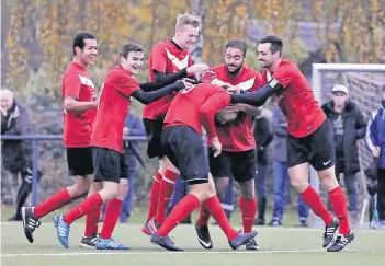  ??  ?? Ein starkes Team: Tobias See (Mitte) wird von seinem Teamkamera­den nach seinem Tor zum 2:0 geherzt.