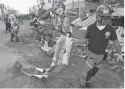  ?? DITA ALANGKARA/THE ASSOCIATED PRESS ?? Rescue workers clear a street from debris caused by typhoon Haiyan in Guiuan, Philippine­s on Friday. A week after the typhoon struck the Philippine­s, there was a spirit of resilience as the residents started rebuilding their lives.