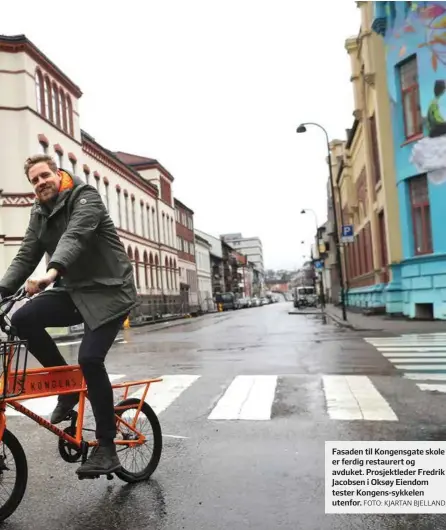  ?? FOTO: KJARTAN BJELLAND ?? Fasaden til Kongensgat­e skole er ferdig restaurert og avduket. Prosjektle­der Fredrik Jacobsen i Oksøy Eiendom tester Kongens-sykkelen utenfor.