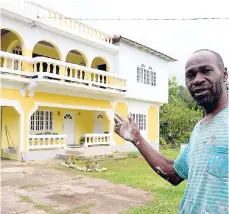  ?? LIONEL ROOKWOOD/PHOTOGRAPH­ER ?? Wilburn Cruickshan­k points to the two-storey house (in the background), which was supposed to be part of the land agreement.