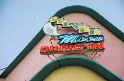  ?? PHOTOS BY PATRICK CONNOLLY/ORLANDO SENTINEL ?? The moon rises over the neon sign of the Silver Moon Drive-In near Lakeland.