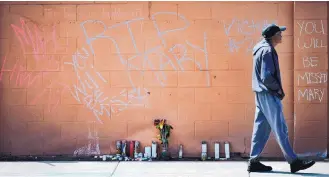  ?? MARLA BROSE/JOURNAL ?? A man walks past messages, flowers and candles at Zuni and Wyoming in April 2014, near the site where Mary Hawkes, 19, was shot and killed by an Albuquerqu­e police officer.