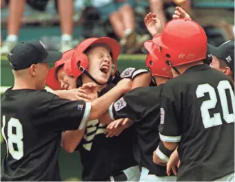 ?? FILE PHOTO BY RUSTY KENNEDY, AP ?? Todd Frazier, center, is mobbed by his Toms River, N.J., teammates after hitting a home run in the 1998 Little League World Series. Frazier’s team went on to win the tournament.