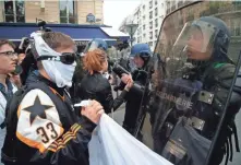  ?? CLAUDE PARIS, AP ?? High school students face down riot police officers Friday in Paris ahead of France’s landmark presidenti­al election.