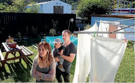  ?? PHOTO: ROSS GIBLIN\FAIRFAX NZ ?? First homeowners Beba McLean and Matthew Robinson with son Teo Robinson have been fighting neighbour Kiwirail over its busy depot behind their back fence on a residentia­l-zoned property in Paekakarik­i, north of Wellington.