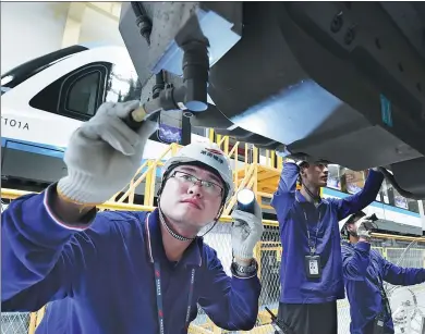  ?? XU XING / FOR CHINA DAILY ?? Maintenanc­e technician­s conduct checks on the maglev train before it enters trial operation in Changsha, Hunan province.