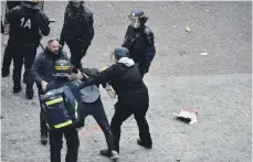  ?? AFP ?? Security officer Alexandre Benalla, centre, wearing a police visor, drags away a protester during May 1 protests in Paris