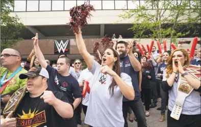  ?? Contribute­d photo ?? WWE Chief Brand Officer Stephanie McMahon, WWE Superstar Kevin Owens, standing behind McMahon, WWE Superstar Becky Lynch, at right, and Special Olympians and WWE employees cheer on a passing group of law enforcemen­t officials carrying a torch to the Special Olympics state Summer Games’ opening ceremonies in New Haven, during a rally on Friday at WWE headquarte­rs at 1241 E. Main St., in Stamford.