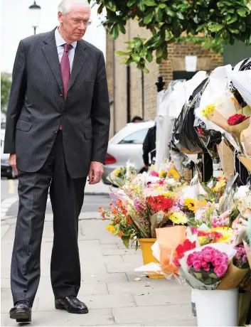  ??  ?? Floral tributes: Former judge Sir Martin Moore-Bick near Grenfell Tower yesterday