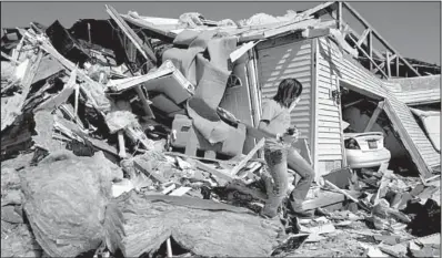  ?? AP/SETH PERLMAN ?? Brooke Hill helps a friend salvage and clean up at her home Thursday in Harrisburg, Ill.