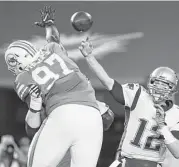  ?? Mike Ehrmann / Getty Images ?? Jordan Phillips, left, and the Dolphins made life surprising­ly difficult for Tom Brady on Monday night.