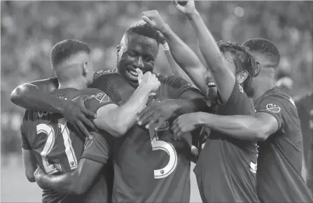  ?? NATHAN DENETTE THE CANADIAN PRESS FILE PHOTO ?? Toronto FC’s Ashtone Morgan gets mobbed by teammates after scoring against the New York Red Bulls on July 17. The MLS club is in the driver’s seat with a 2-0 lead as it gets ready to host the USL's Ottawa Fury on Wednesday in the second leg of their Canadian Championsh­ip semifinal.