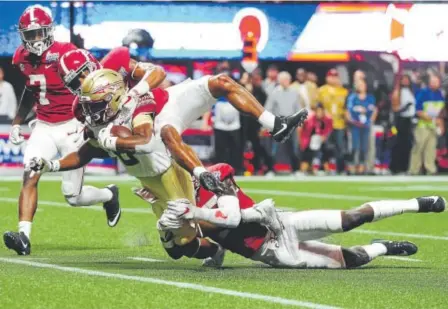  ?? Scott Cunningham, Getty Images North America ?? Alabama’s Anthony Averett tackles Florida State’s Nyqwan Murray in Saturday night’s game at the new $1.5 billion Mercedes-benz Stadium in Atlanta. The Crimson Tide beat the Seminoles 24-7.