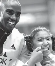  ?? MAXIM SHEMETOV / REUTERS ?? Gold medalist Mo Farah of Britain poses with his daughter, Rihanna, at the men’s 5,000m victory ceremony during the IAAF World Athletics Championsh­ips in Luzhniki Stadium in Moscow on Friday.