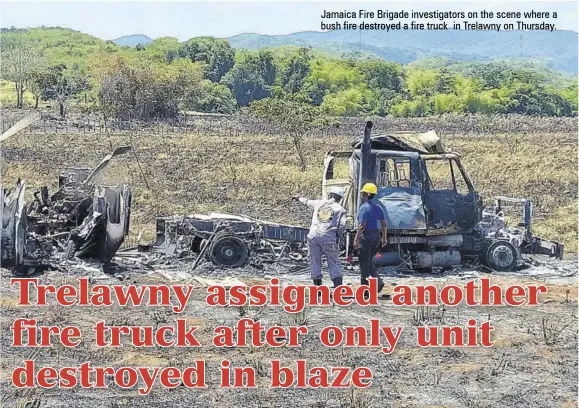  ??  ?? Jamaica Fire Brigade investigat­ors on the scene where a bush fire destroyed a fire truck in Trelawny on Thursday.